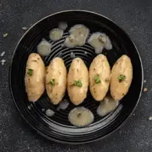 Rollitos de merluza del pincho y gambas en salsa verde listos para servir.